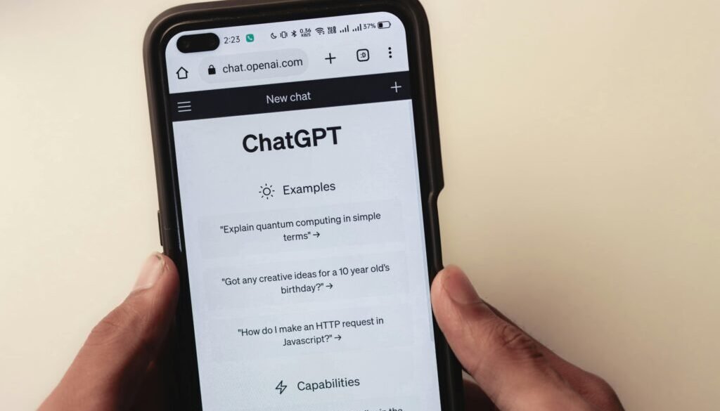 Close-up of hands holding a smartphone displaying the ChatGPT application interface on the screen.